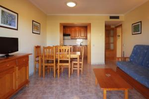 una sala de estar con una mesa y un sofá en Apartamentos Imperial, en Salou