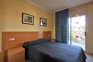 a bedroom with a bed and a window at Apartamentos Imperial in Salou