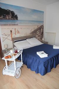Una cama con un carro con comida en una playa en Casa Laura en Terracina