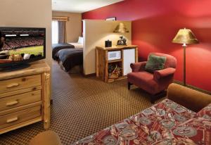 Habitación de hotel con cama y TV en Arrowwood Lodge at Brainerd Lakes en Baxter