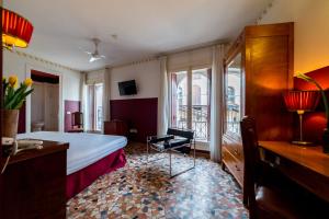 a hotel room with a bed and a desk and window at Antico Hotel Vicenza in Vicenza