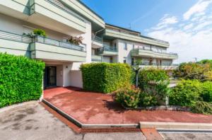 a building with bushes and a yard in front of it at Royal Standing- Terrasse & Parking Privé in Évian-les-Bains