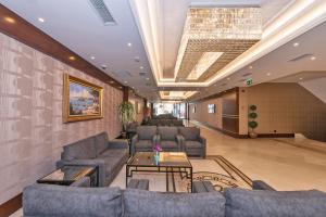 a living room with couches and a chandelier at Piya Sport Hotel in Istanbul