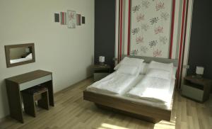 バヤにあるSugó Panzióのベッドルーム1室(白い枕2つ付きのベッド1台付)