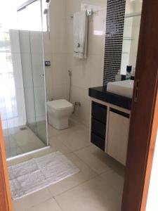 ein Bad mit einer Dusche, einem WC und einem Waschbecken in der Unterkunft Casa de Família in Capitólio