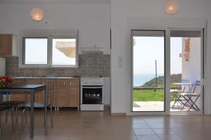 KamáriaにあるHelona Housesのキッチン(テーブル付)、景色を望むダイニングルームが備わります。