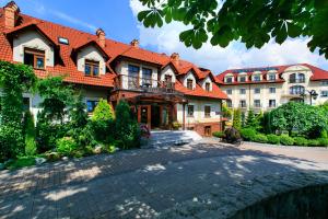 una casa grande con techo rojo en Hotel Galicja Superior Wellness & Spa, en Oświęcim