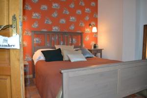 La Longère d'Ecottes في Licques: غرفة نوم بسرير بحائط برتقالي