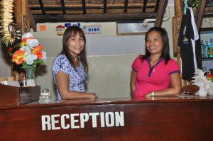 Due donne in piedi al bancone in un bar di SLAM'S Garden Dive Resort a Isola di Malapascua
