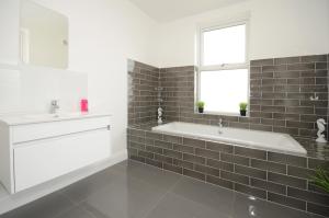 een badkamer met een ligbad en een wastafel bij York Boutique House- spacious & stylish with free parking in York +24 foto's