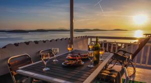 a table with wine glasses and a bowl of food at The perfect stay in Hvar