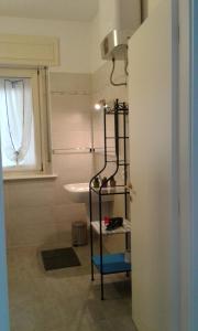 a bathroom with a sink and a shelf in a room at B&B Homer Trento in Trento