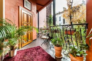 a balcony with potted plants and a door at Aparthotel Oberża in Krakow