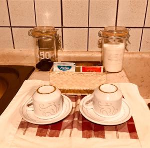 dos platos blancos sentados en un mostrador de cocina al lado de tarros en Serranello Azienda Agricola, en Bono