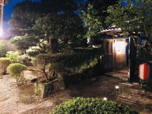 un jardín con una puerta de madera y una valla en Guest House Wagaranchi Kai, en Kumano