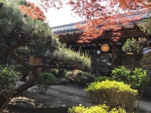 un giardino di fronte a una casa con un albero di Guest House Wagaranchi Kai a Kumano