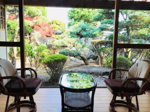 熊野市にあるゲストハウスわがらん家 海の椅子とテーブル付きの窓から庭園の景色を望めます。