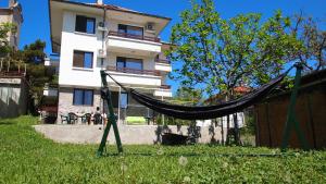 a hammock in the grass in front of a building at Villa Burkopolis in Sozopol