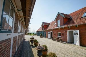 einem Innenhof aus zwei Backsteingebäuden mit Topfpflanzen in der Unterkunft Ferienwohnungen auf dem Carlshof in Jork - Altes Land in Jork