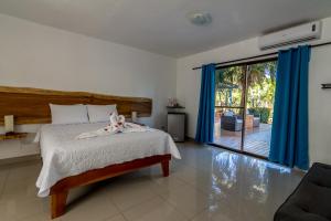 a bedroom with a bed and a large window at CLUB IBIZA - Party Hotel & Beach Club in Jacó