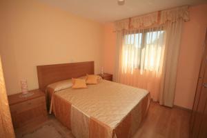 - une chambre avec un lit doté d'oreillers jaunes et d'une fenêtre dans l'établissement Villa Egida Capris, à Lovrečica