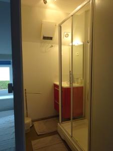 a bathroom with a glass shower and a sink at La Cour du Bourg in Saint-Jean-des-Champs