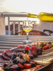 een dienblad met eten op een tafel met een glas wijn bij The perfect stay in Hvar