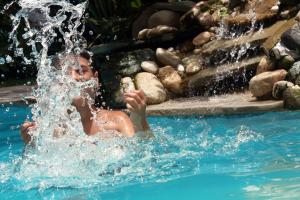 a young boy playing in the water in a swimming pool at Hotel Villa Taina in Cabarete