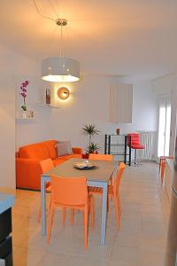 a living room with a table and orange chairs at Cabà Holiday Bardolino Gritti in Bardolino