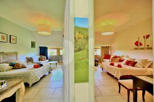 a bedroom with two beds and a living room at Les Deux Moiselles - Le Cheyssignaguet in La Chapelle-Aubareil