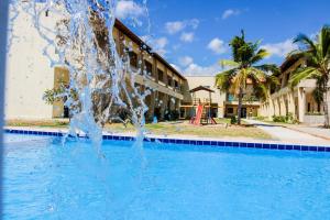 a fountain in the middle of a swimming pool at Pousada Itarema Residence in Itarema
