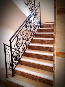 um conjunto de escadas com corrimão de ferro forjado em Best Guest Apartments em Plovdiv