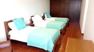 een kamer met 4 bedden met blauwe en witte lakens bij Vivenda Cabral in Funchal