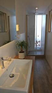 W łazience znajduje się biała umywalka i lustro. w obiekcie Hostal La Palma w mieście Fornells