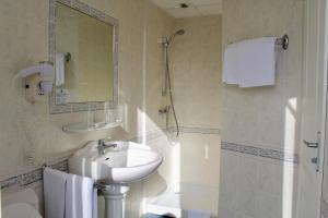 a bathroom with a sink and a mirror and a shower at Hôtel Sainte Marie in Lourdes +30 photos