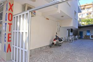 uno scooter parcheggiato fuori da un edificio accanto a un edificio di Family Hotel Blazhi a Sandanski Altre 8 foto
