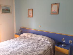 1 dormitorio con 1 cama y 2 mesas azules en Hotel Halifax, en Lido di Jesolo