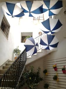 una escalera con sombrillas azules y blancas colgando del techo en Coraje Room & Breakfast, en Sciacca
