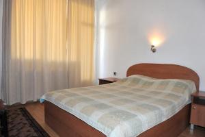 una piccola camera da letto con un letto e una finestra di Family Hotel Blazhi a Sandanski