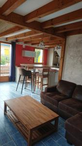 a living room with a couch and a table at Maison ocelandes in Saint-Julien-en-Born