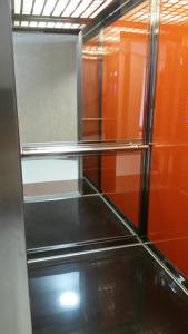 a glass shelf in a room with orange walls at Kolonaki Domus Apartment in Iaşi