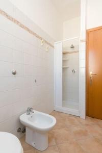 a white bathroom with a toilet and a sink at Casa Irene in San Vito lo Capo