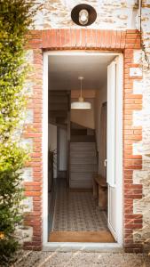 an open door of a brick building with a window at Il Etait Une Fois Chez Moi - La Maison De Tante Marie in Le Loroux-Bottereau +3 photos