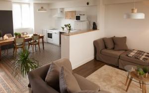 a living room with a couch and a table and a kitchen at Il Etait Une Fois Chez Moi - La Maison De Tante Marie in Le Loroux-Bottereau
