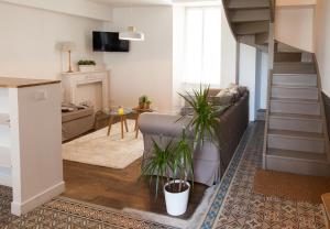 a living room with a couch and a stair case at Il Etait Une Fois Chez Moi - La Maison De Tante Marie in Le Loroux-Bottereau