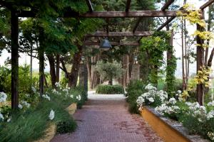 a walkway in a garden with white flowers at Resort e Spa San Crispino in Assisi