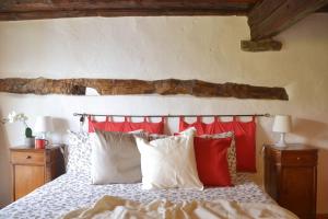 カンノビオにあるCasa la Finestra sul Lago - WelcHomeのベッドルーム1室(赤と白の枕が備わるベッド1台付)