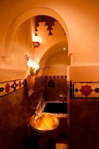 baño con lavabo y puerta abovedada en Riad Noga, en Marrakech