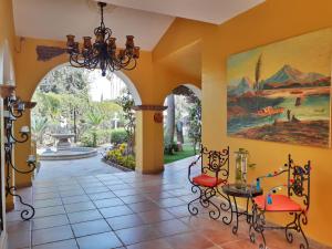un couloir avec un lustre, une table et des chaises dans l'établissement El Encanto Inn & Suites, à San José del Cabo