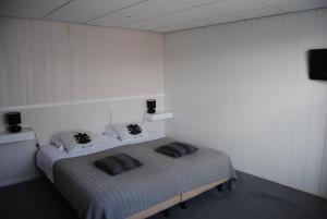 een slaapkamer met een bed met 2 kussens erop bij Het Verschil in Zoutelande